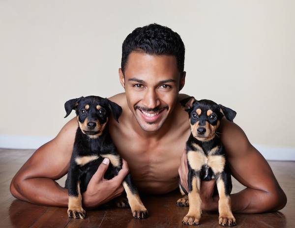Shirtless Man With Two Puppies